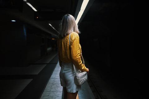 Eine Frau steht alleine im U-Bahn-Tunnel