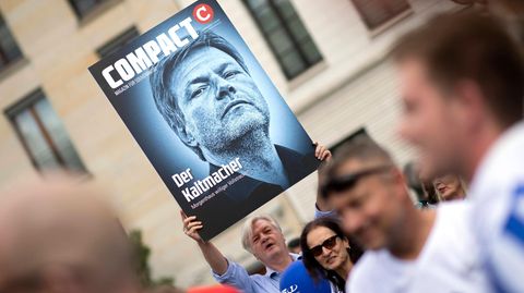 Jürgen Elsässer hält ein Cover des Compact-Magazins in die Luft