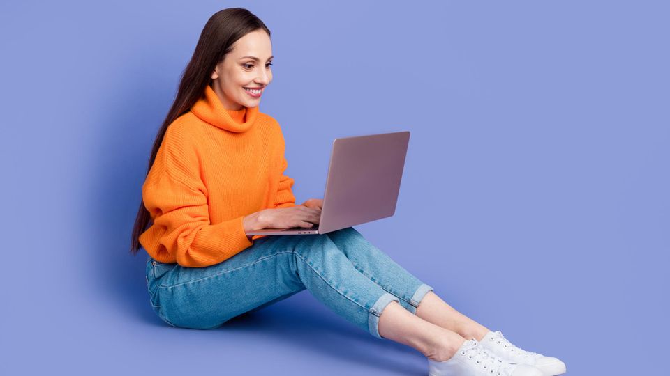 Amazon Prime Day 2024: Junge Frau mit MacBook auf dem Shoß