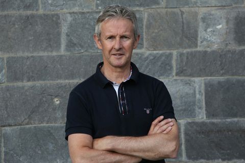 Jens Weißflog im Polo-Shirt vor einer grauen Steinwand.