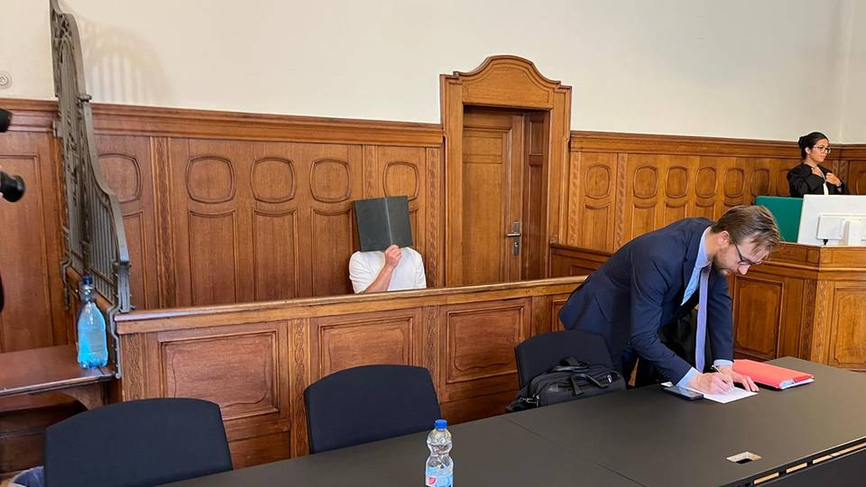 Gyunay K. hält sich am Landgericht in Berlin einen Ordner vors Gesicht. Er ist wegen Vergewaltigung angeklagt.