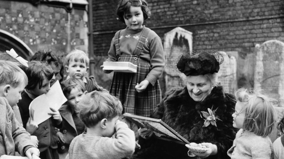 Maria Montessori umringt von Kindern