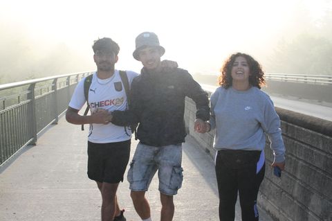 Geflüchtete junge Menschen im Morgenlicht auf einer Brücke