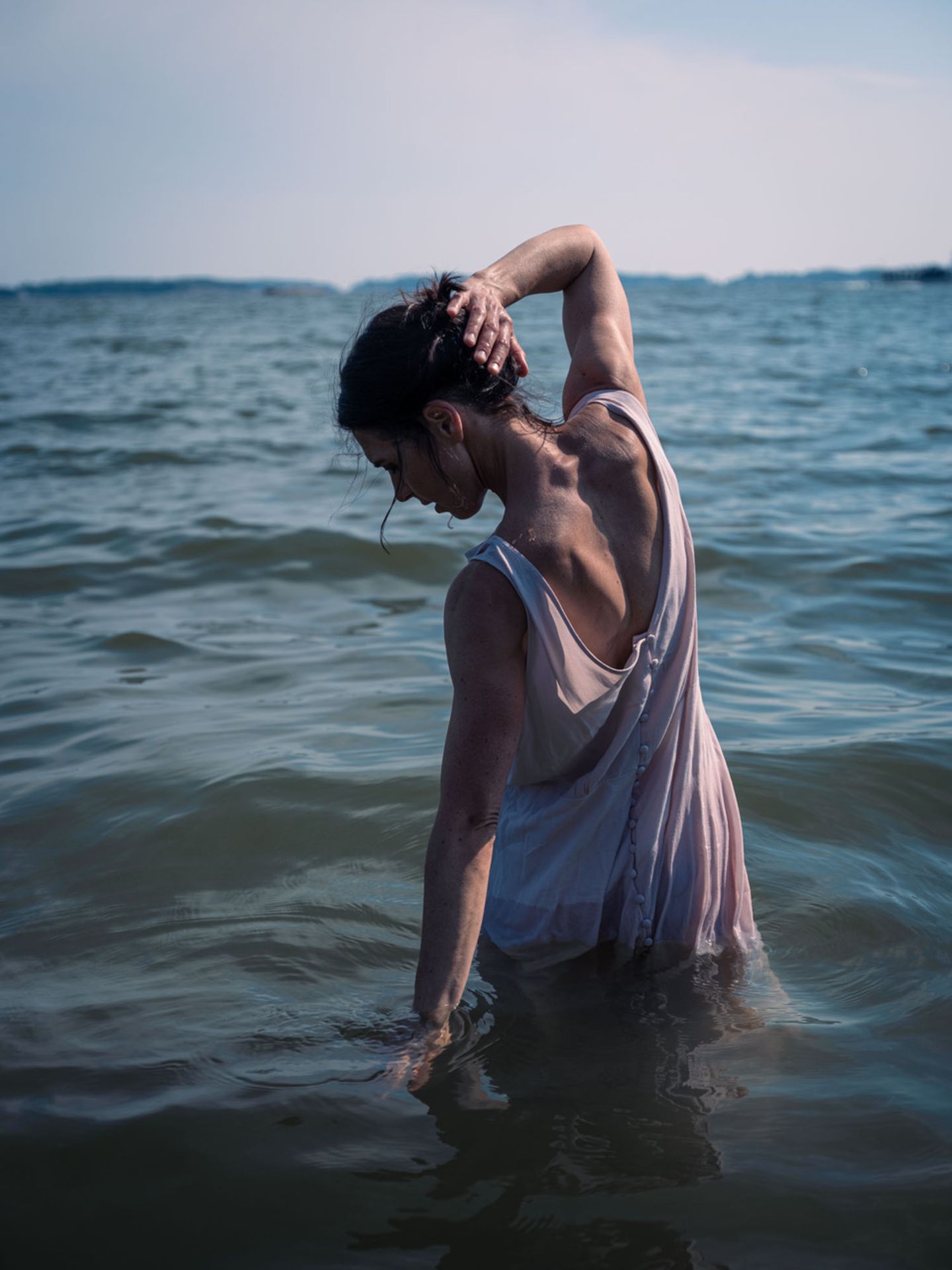 Eine Frau von hinten, die im Wasser steht. Es ist Autorin Hanna Brotherus, die einen Roman über Essstörungen schrieb