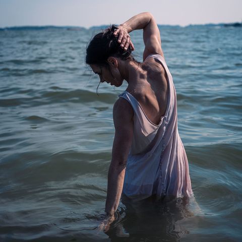 Eine Frau von hinten, die im Wasser steht. Es ist Autorin Hanna Brotherus, die einen Roman über Essstörungen schrieb