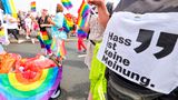 Ein Teilnehmer des CSD Köln trägt ein Schild mit einer wichtigen Message "Hass ist keine Meinung"