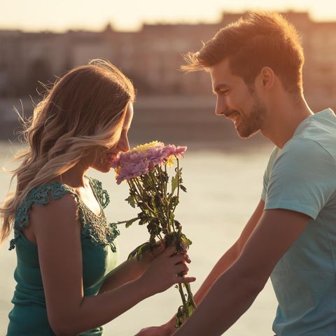 Ein junger Mann verschenkt Blumen an seine Freundin