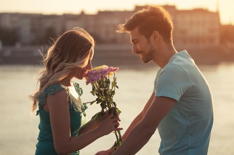 Ein junger Mann verschenkt Blumen an seine Freundin