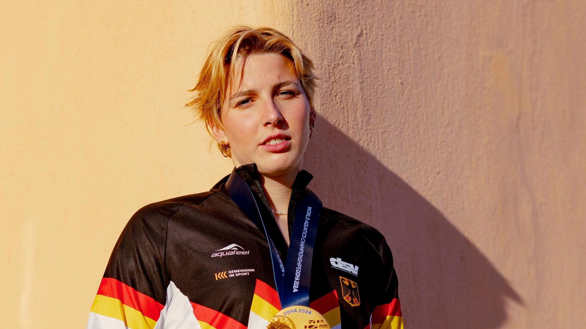 Portrait von Angelina Köhler mit ihrer Goldmedaille im Schwimmen