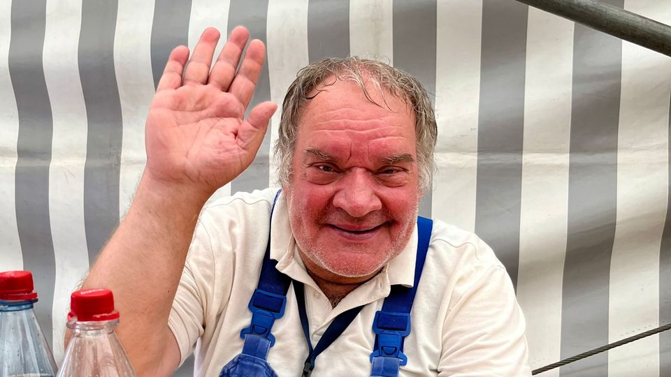 Mann winkt in Kamera
