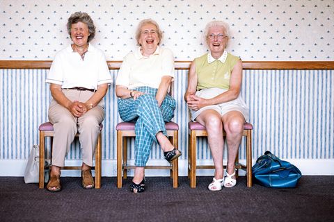 Besser Altern: Drei Seniorinnen sitzen lachend nebeneinander