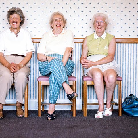 Besser Altern: Drei Seniorinnen sitzen lachend nebeneinander