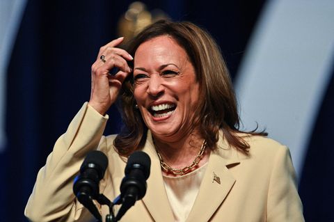 Kamala Harris im weißen Sakko strahlt in die Kamera