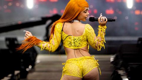 Rapperin Ice Spice mit Perücke in Orange und Hotpans aus gelber Spitze auf der Bühne