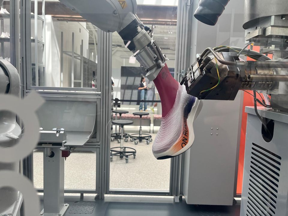 Fäden, so fein, dass man sie kaum sieht: Der Roboterarm sprüht das Obermaterial auf die Sohle – in drei Minuten ist der Schuh fertig 
