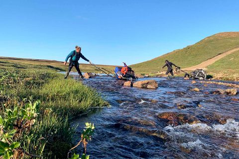 Die Männer überqueren einen Fluss