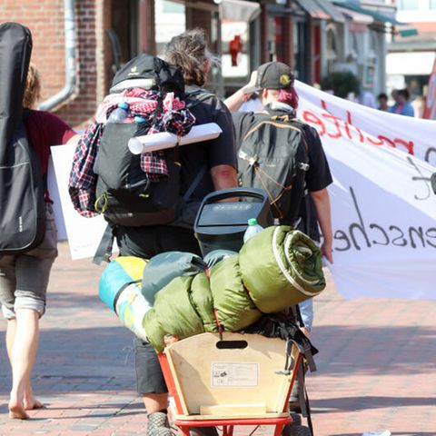 Punks auf Sylt tragen Taschen und Rucksäcke