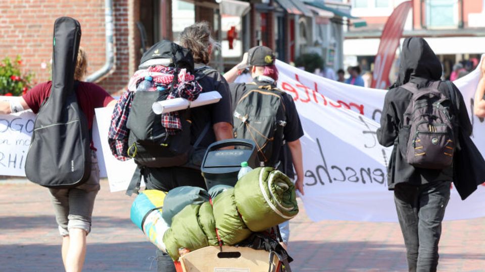 Punks auf Sylt tragen Taschen und Rucksäcke