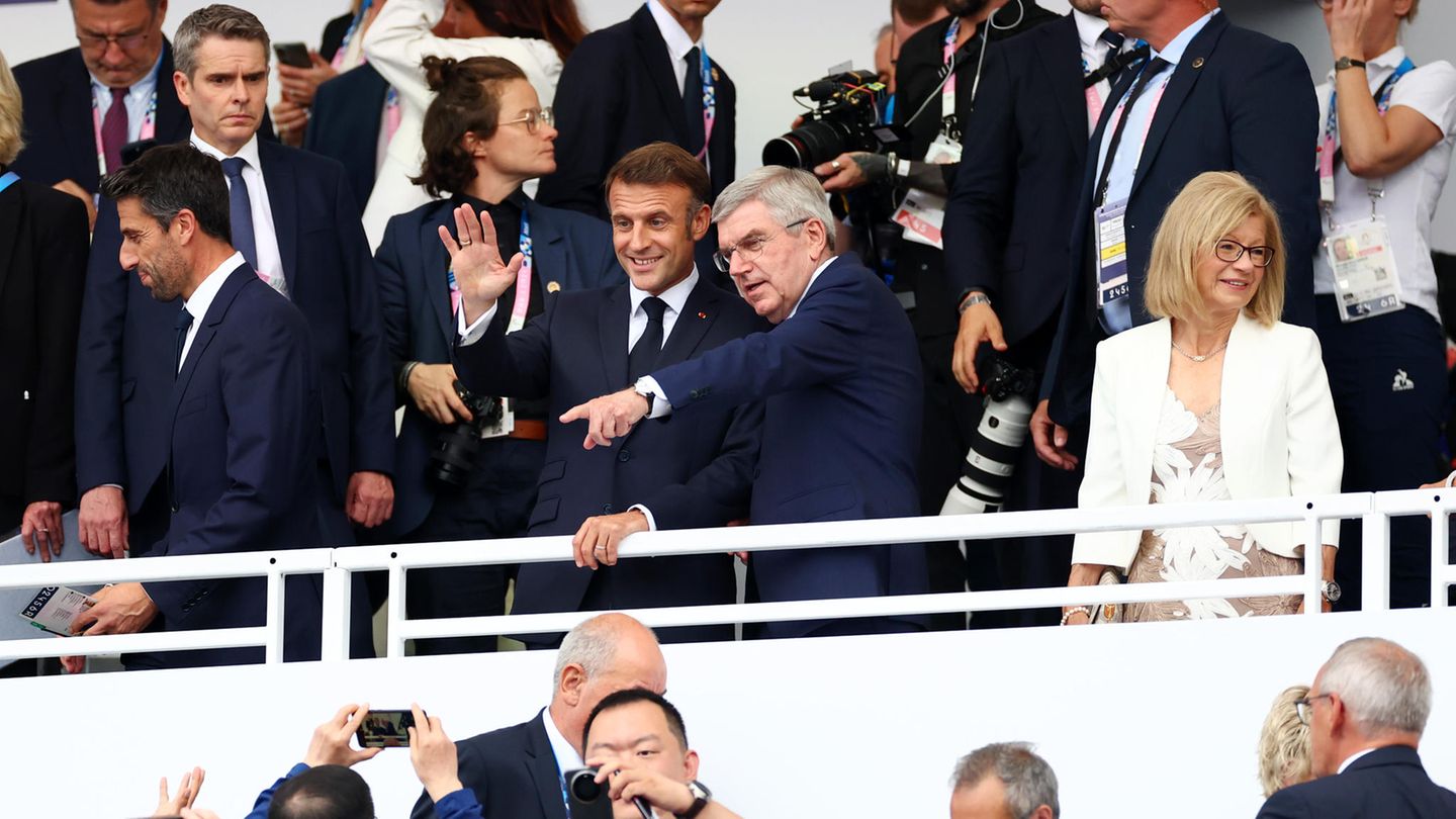 Auf der Tribüne am Trocadéro am Eiffelturm, wo die große Parade enden wird, finden sich der französische Präsident Emmanuel Macron und IOC-Präsident Thomas Bach ein