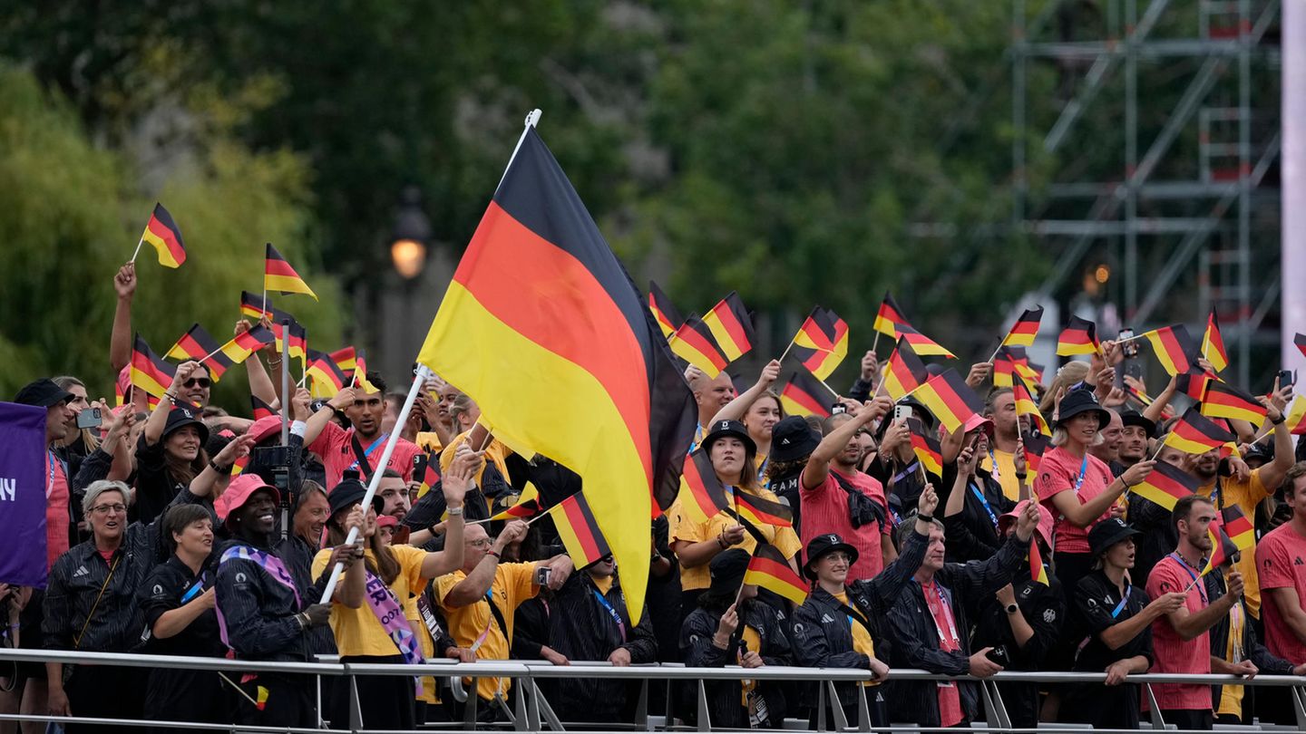 Die deutsche Olympia-Mannschaft fährt auf dem dritten Boot. Vorne links sind die deutschen Fahnenträger zu sehen, der Basketballer Dennis Schröder und die Judo-Kämpferin Anna-Maria Wagner