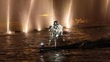 Dann wird es lässig: Die silberne Reiterin trägt die olympische Fahne als Umhang und reitet über die Seine
