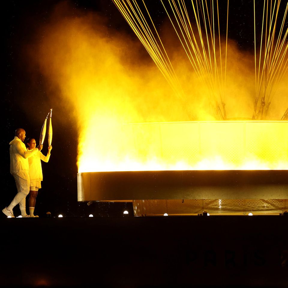 Der magische Moment: Die Leichtathletin Marie-José Pérec und der Judoka Teddy Riner entzünden die olympische Flamme in den Tuilerien am Louvre. Sie besteht aus einem Ring mit sieben Metern Durchmesser, der an einem 30 Meter hoch schwebendem Ballon hängt 