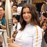 Eine Frau trägt eine Fackel für Olympia