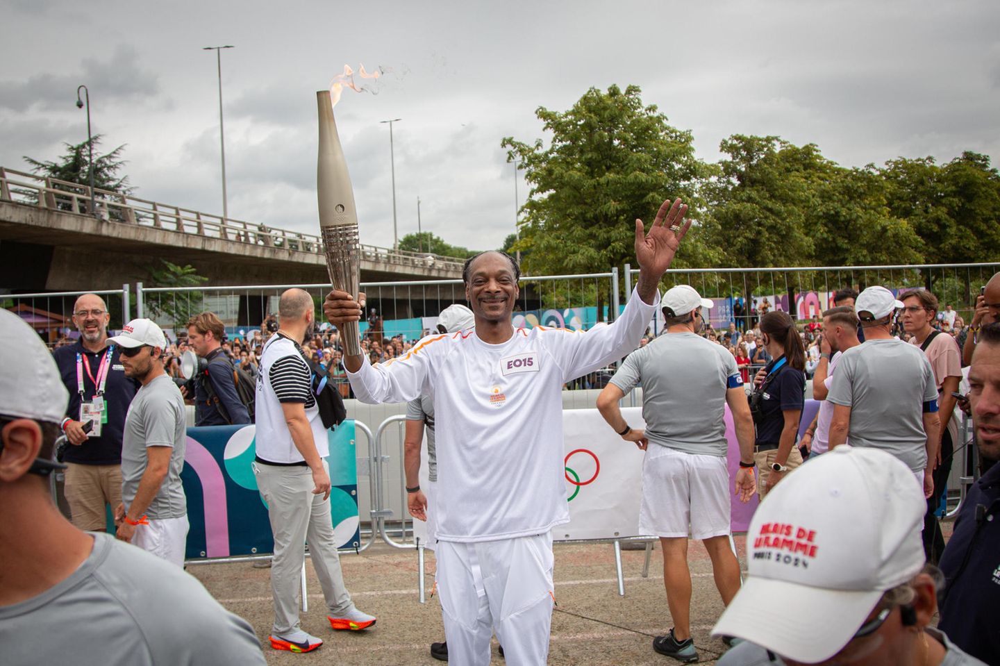 Rapper Snoop Dog trägt sichtlich stolz das Olympische Feuer