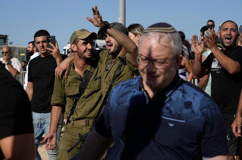 Israelische Soldaten und rechtsgerichtete Demonstranten protestieren vor dem Tor des Militärstützpunkts Sde Teiman, um die beschuldigten Soldaten zu unterstützen