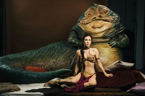Eine Frau sitzt leicht bekleidet vor einem Monster (Jabba the Hutt: Star Wars )