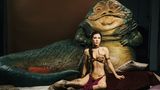 Eine Frau sitzt leicht bekleidet vor einem Monster (Jabba the Hutt: Star Wars )