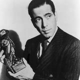 Ein Mann hält eine Falken Bleifigur in der Hand und schaut an der Kamera vorbei.