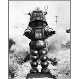 Robby der Roboter steht frontal mit ausgestreckten Armen in der Öde.