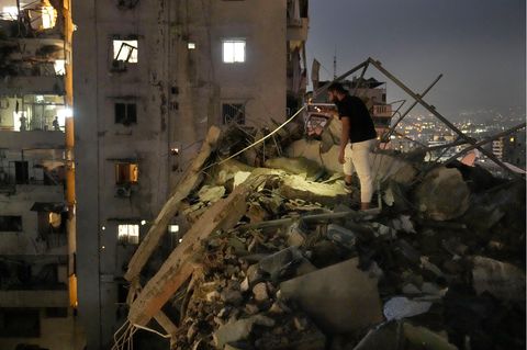 in Mann inspiziert die Trümmer auf dem zerstörten Gebäude in einem Vorort von Beirut