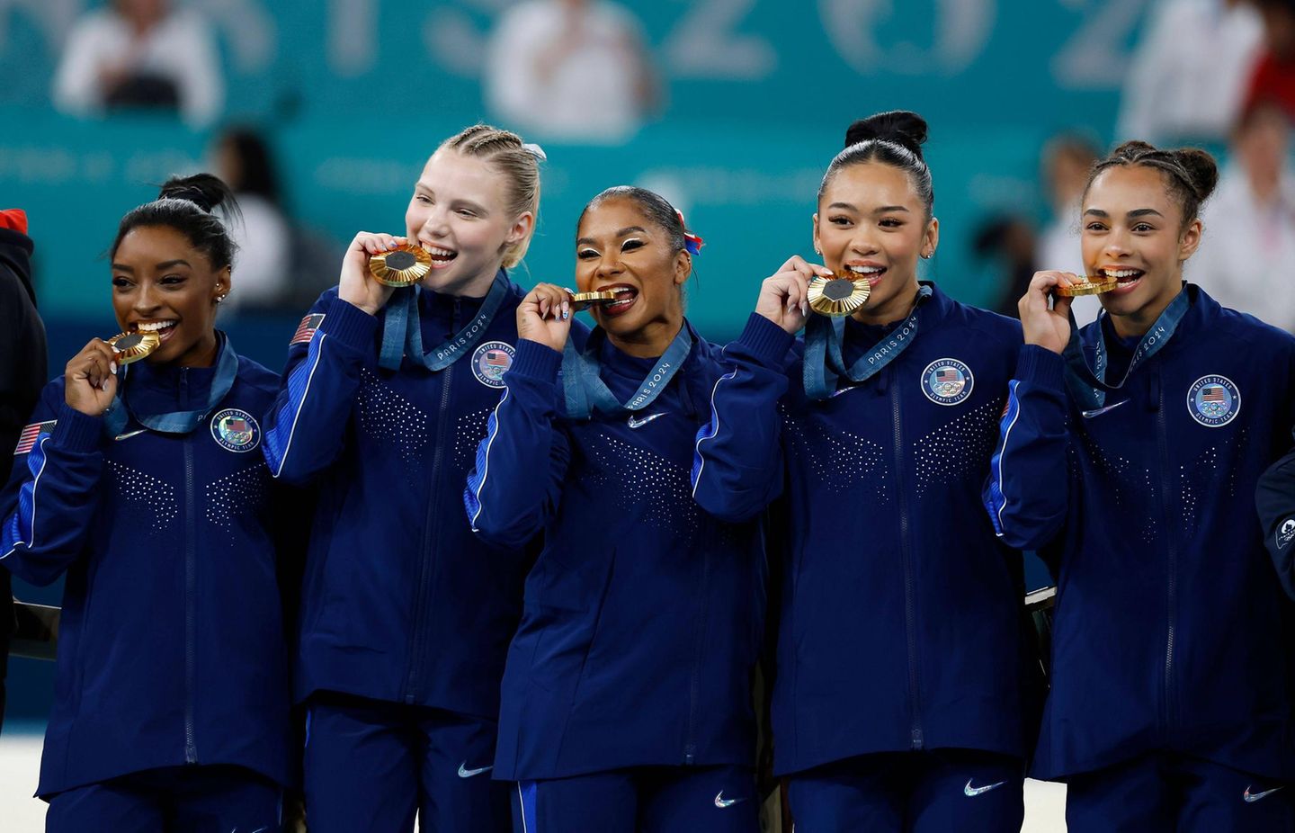 Olympia 2024: Simone Biles, Jade Carey, Sunisa Lee, Jordan Chiles und Hezly Rivera beißen glücklich auf Olympia-Gold. Noch am Abend vor dem Mannschafts-Finale hatten sich Biles und ihre Mitstreiterinnen zusammengesetzt, weil sie das Gefühl hatten, dass Nervosität im Team herrsche und deswegen miteinander gesprochen. "Wir haben uns einfach gegenseitig unterstützt", berichtete Biles. "Wir hatten das Gespräch und haben uns gegenseitig versichert, dass wir uns aufeinander verlassen können. Es ist wirklich hart, was wir hier machen und es ist einfacher, wenn wir uns aneinander anlehnen können", sagte sie laut dpa. Simone Biles, Jade Carey, Sunisa Lee, Jordan Chiles und Hezly Rivera beißen glücklich auf Olympia-Gold. Noch am Abend vor dem Mannschafts-Finale hatten sich Biles und ihre Mitstreiterinnen zusammengesetzt, weil sie das Gefühl hatten, dass Nervosität im Team herrsche und deswegen miteinander gesprochen. "Wir haben uns einfach gegenseitig unterstützt", berichtete Biles. "Wir hatten das Gespräch und haben uns gegenseitig versichert, dass wir uns aufeinander verlassen können. Es ist wirklich hart, was wir hier machen und es ist einfacher, wenn wir uns aneinander anlehnen können", sagte sie laut dpa.