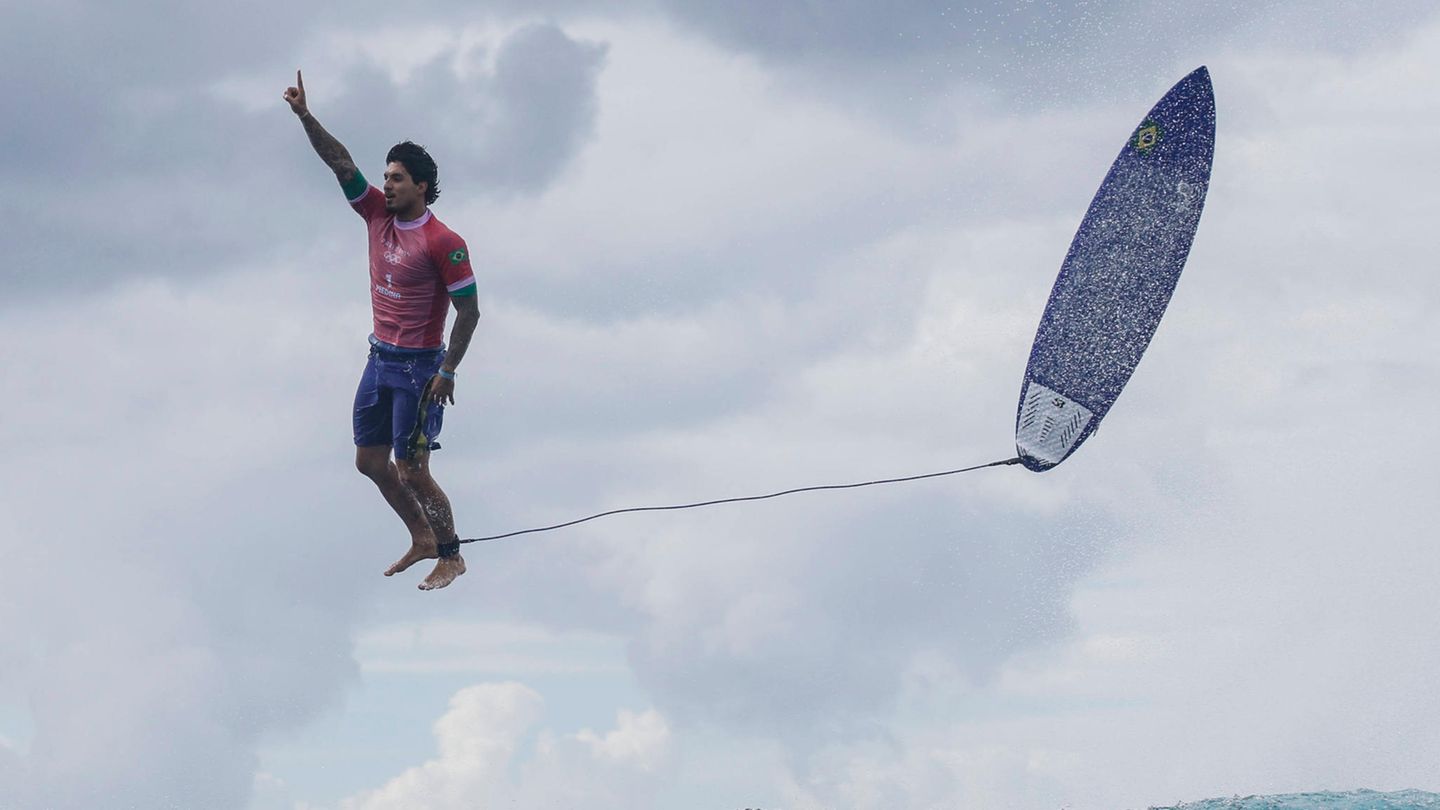 Olympia 2024: Es ist vermutlich das Foto der Spiele: Der AFP-Fotograf Jérôme Brouillet schießt es von einem Boot aus. Zu sehen ist der Surf Superstar Gabriel Medina genau in dem Moment, als er nach seinem Ritt über den Rücken einer Monsterwelle in die Luft springt, wissend, dass alle Kameras auf ihn gerichtet sind Es ist vermutlich das Foto der Spiele: Der AFP-Fotograf Jérôme Brouillet schießt es von einem Boot aus. Zu sehen ist der Surf Superstar Gabriel Medina genau in dem Moment, als er nach seinem Ritt über den Rücken einer Monsterwelle in die Luft springt, wissend, dass alle Kameras auf ihn gerichtet sind