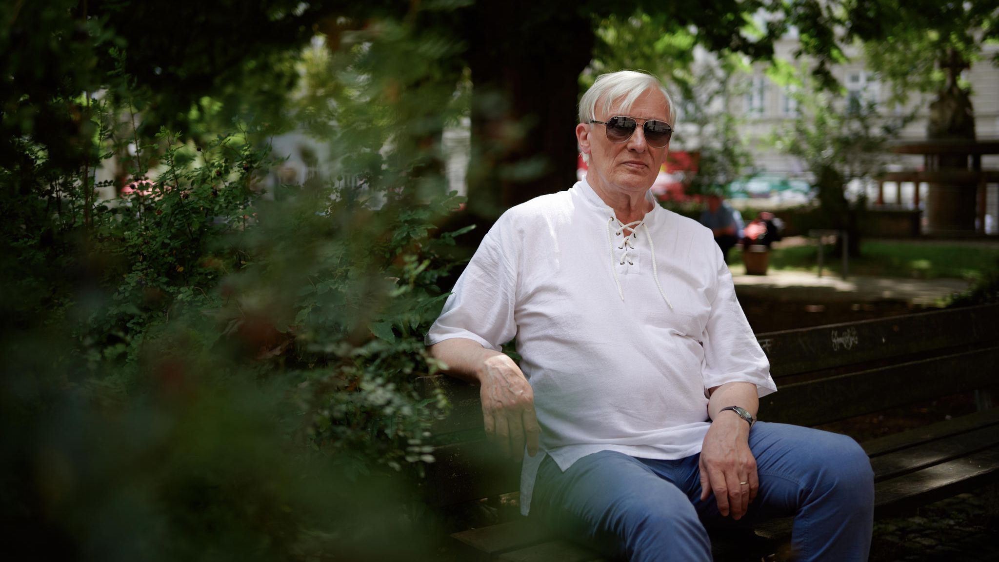 Sexarbeit: Franz sitzt auf einer Bank mit Sonnenbrille