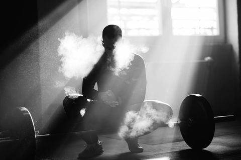 Bodybuilding: Kraftsportler in SW mit Langhantel und Kreidestaub