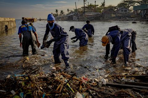 Wegen des ausgelaufenen Öls waten die Helfer mit Schutzkleidung durchs Wasser