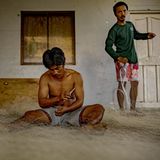 Zwei Männer basteln an ihren Fischernetzen