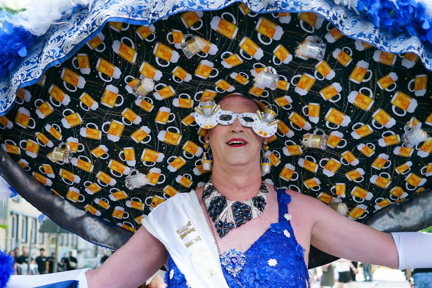 Ein Mannin Frauenkleidung mit einem riesigen Hut