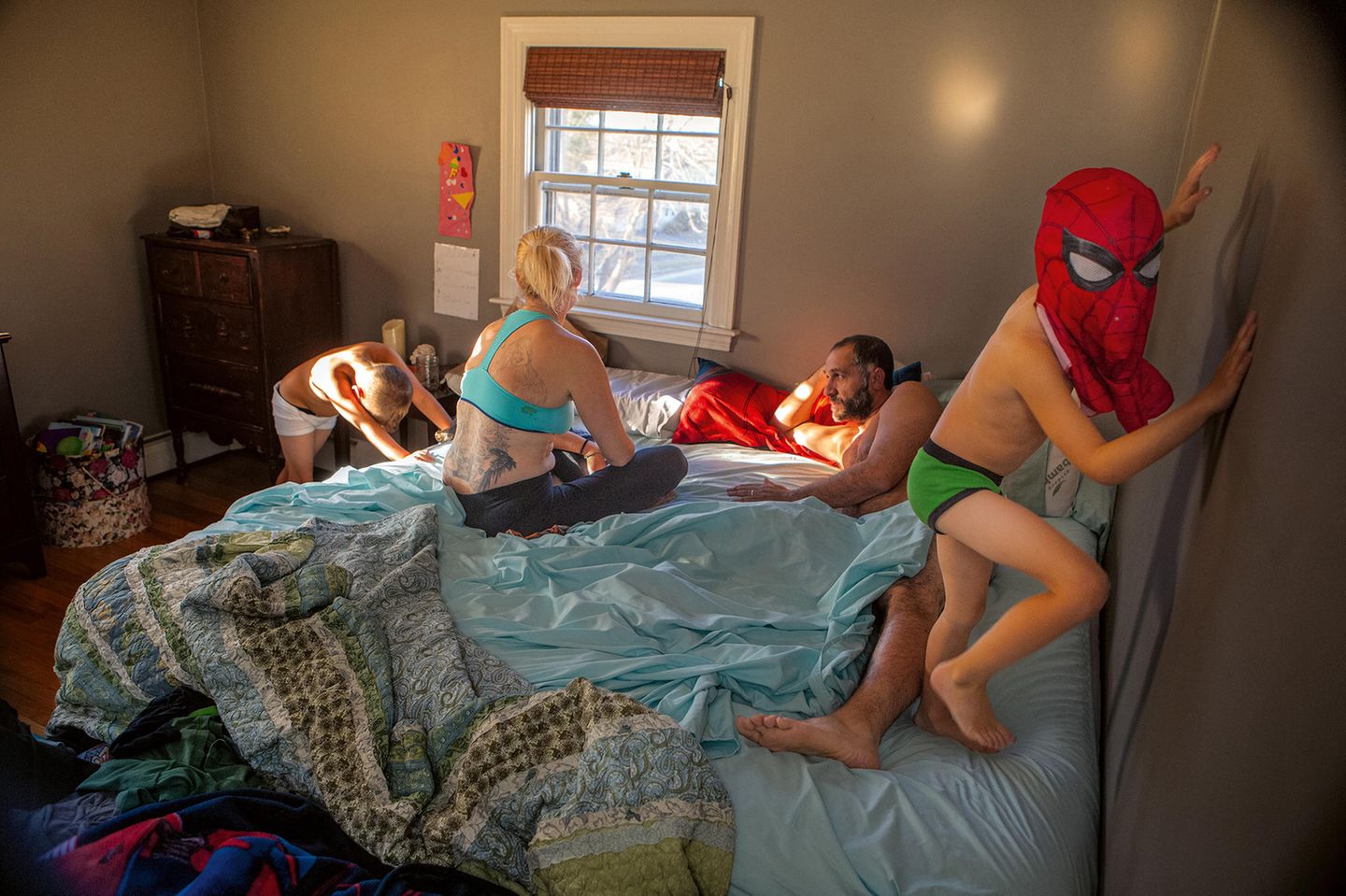 Eine Familie verbringt Zeit im Bett. die Kinder turnen durch das Schlafzimmer. Eine Familie verbringt Zeit im Bett. die Kinder turnen durch das Schlafzimmer.