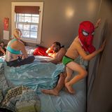 Eine Familie verbringt Zeit im Bett. die Kinder turnen durch das Schlafzimmer.