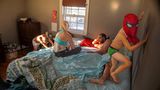 Eine Familie verbringt Zeit im Bett. die Kinder turnen durch das Schlafzimmer.