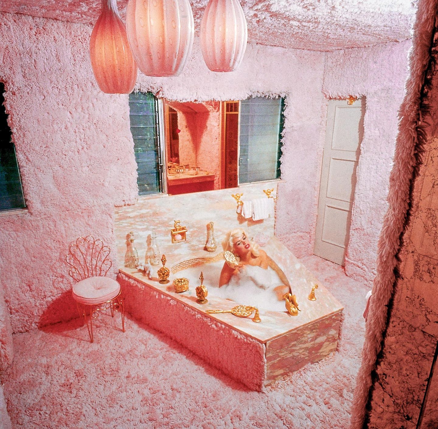Jayne Mansfield in einer pinken Badewanne in einem plüschigen Badezimmer