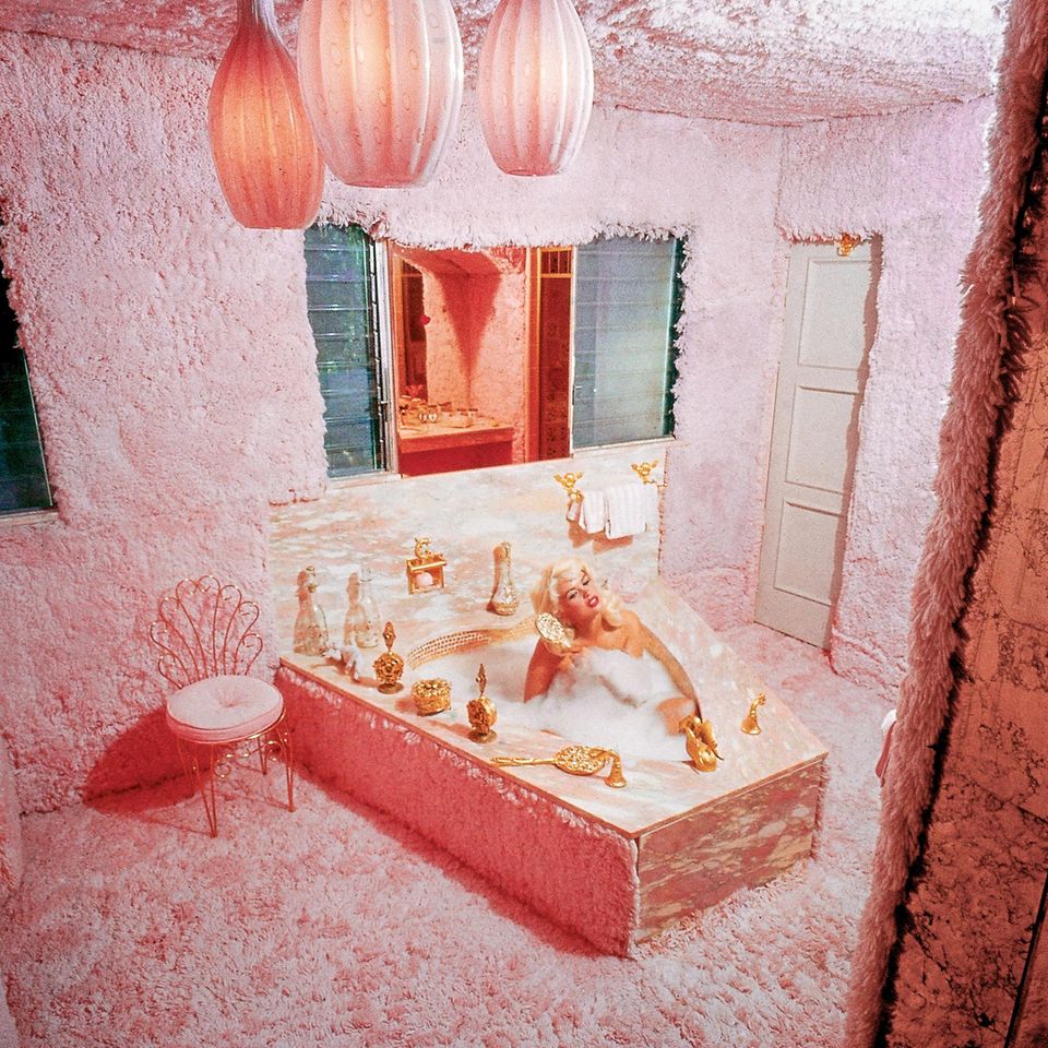 Jayne Mansfield in einer pinken Badewanne in einem plüschigen Badezimmer