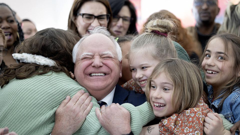 Kinder umarmen Tim Walz