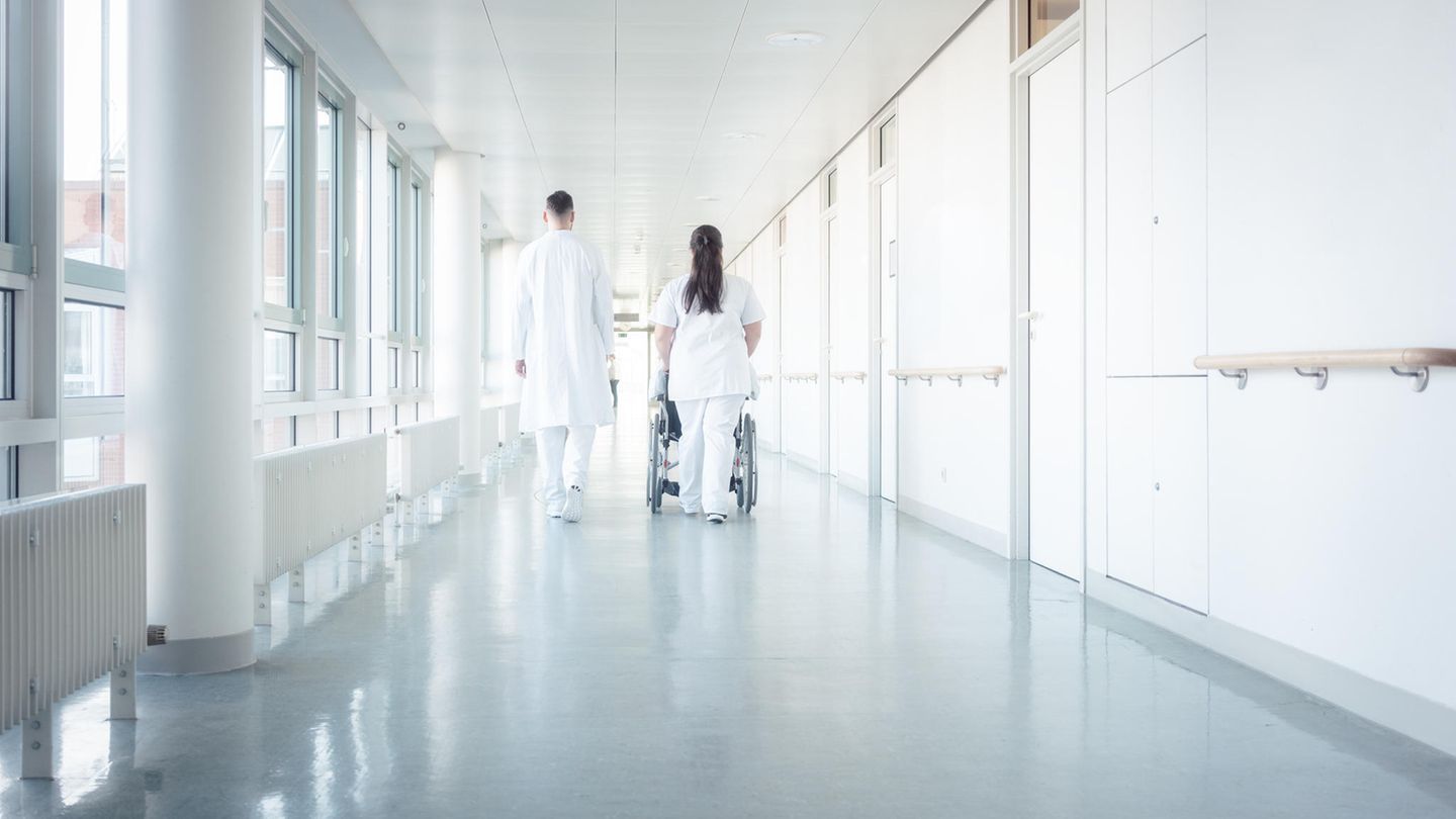 Zwei Menschen in Arztkleidung auf dem Flur eines Krankenhauses