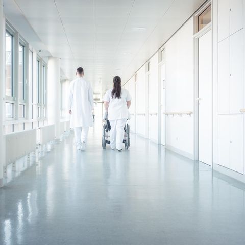 Zwei Menschen in Arztkleidung auf dem Flur eines Krankenhauses