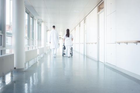 Zwei Menschen in Arztkleidung auf dem Flur eines Krankenhauses
